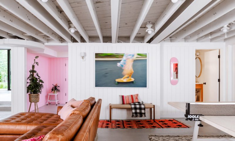 Modern basement renovation showcasing vibrant pink accents and a comfortable seating area.