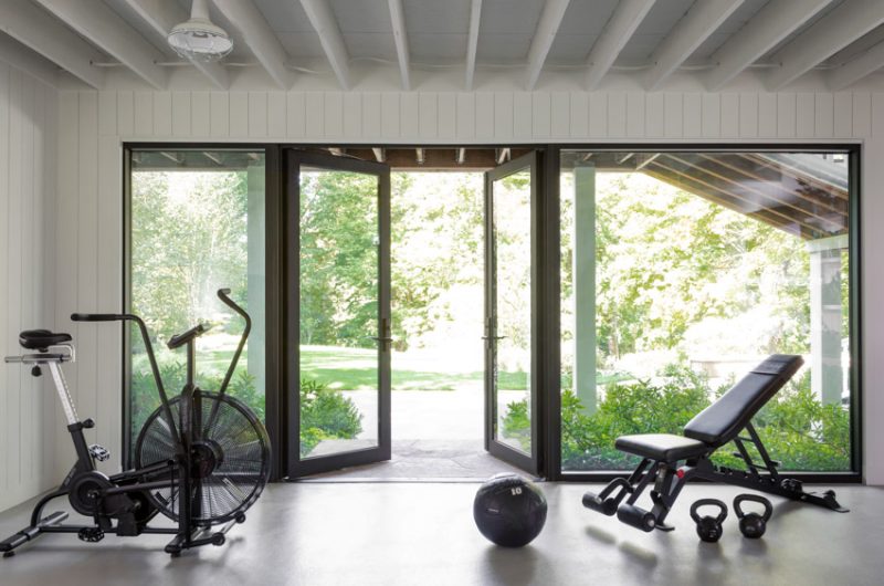 Contemporary home gym setup in a remodeled space with sleek equipment and ample natural light.